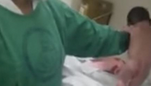 Porodní asistentka drží novorozence a ten po několika vteřinách dělá něco, čemu 